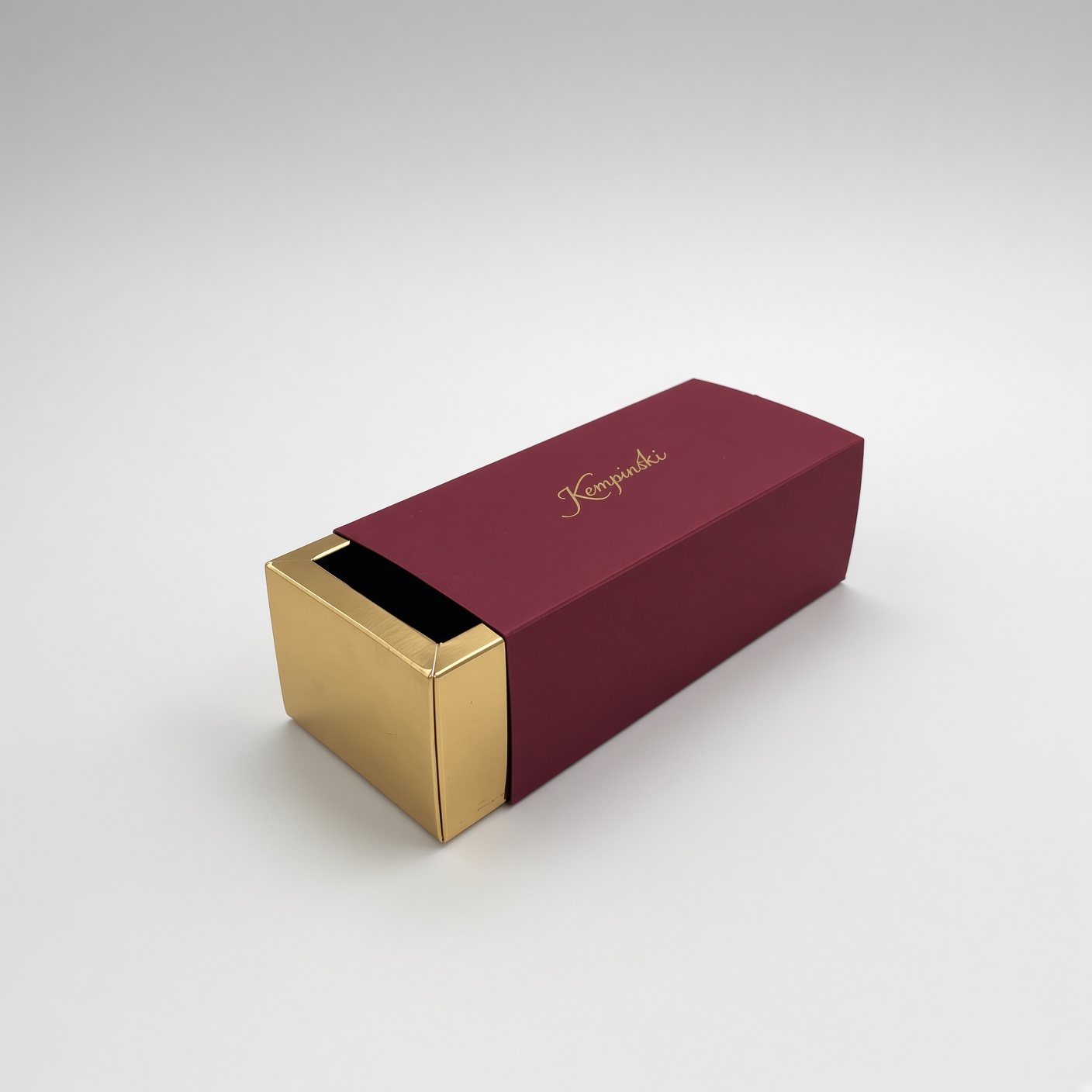 Burgundy sleeve with a gold logo and a gold pull-out drawer