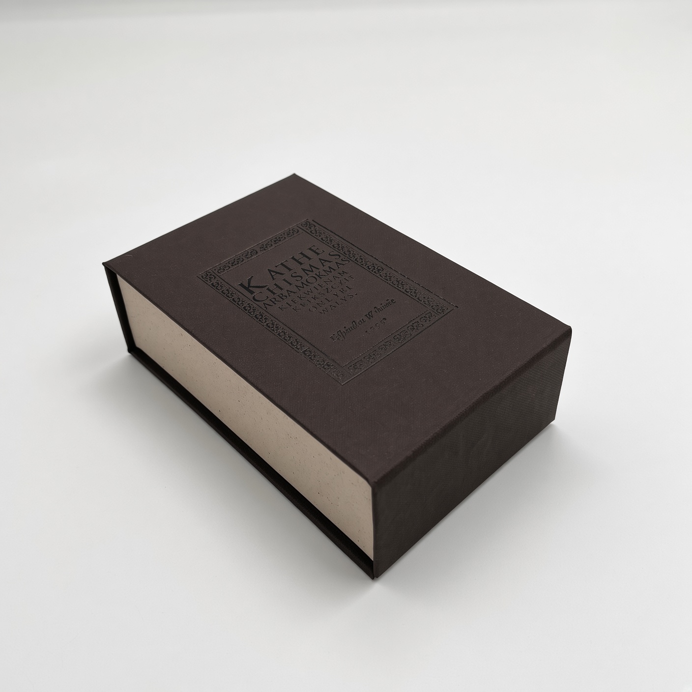 Dark brown magnetic box with an embossed logo and light inner edges