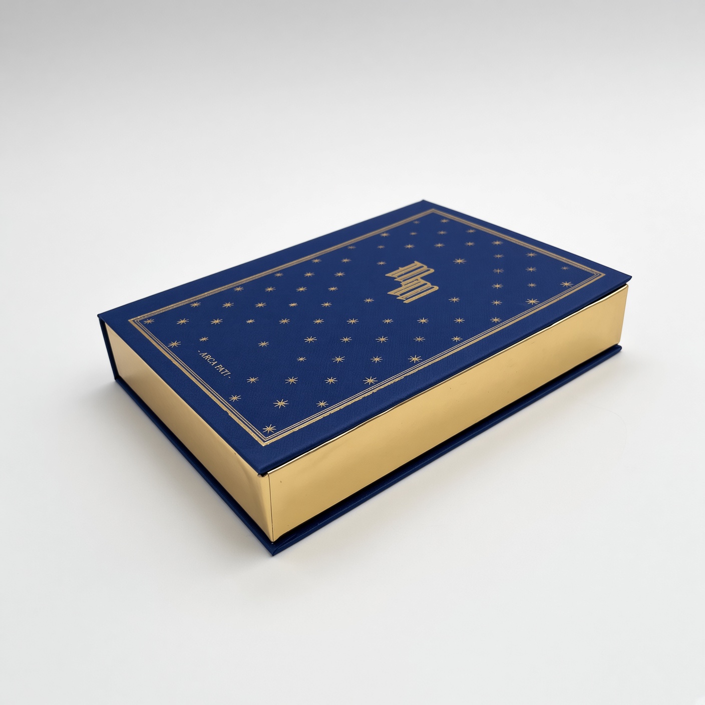 Dark blue book-shaped box with a gold pattern and gilded edges