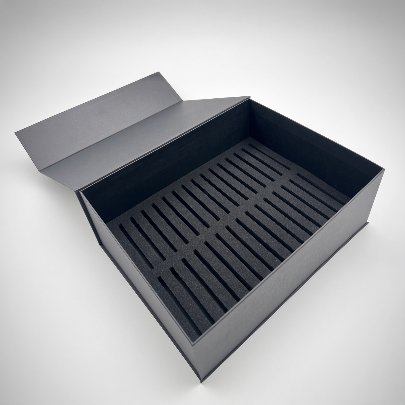 Black magnetic hinged box with a black rubber insert with many parallel slots
