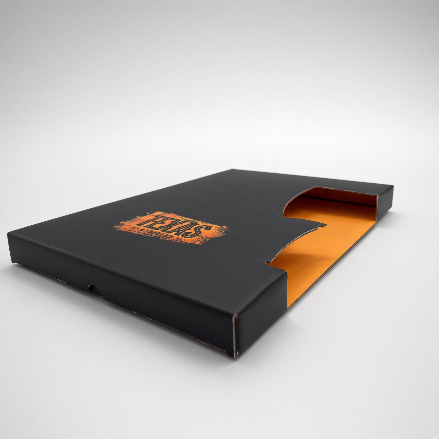 Black slipcase with an orange logo, holding an orange folder
