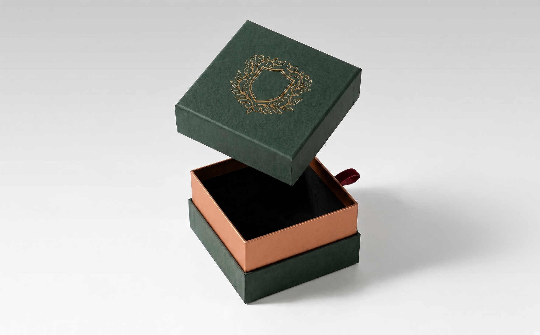 Dark green lid-and-base box with a gold foil ornament and a copper-toned inner tray